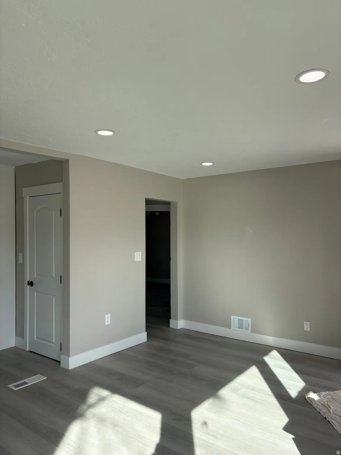 Living room featuring light laminate floors, a textured ceiling, and recessed lighting