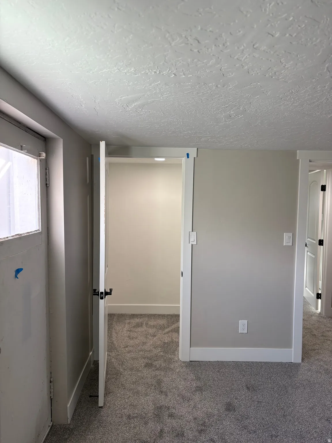 Bedroom 3 walk in closet light grey carpet floors and a textured ceiling