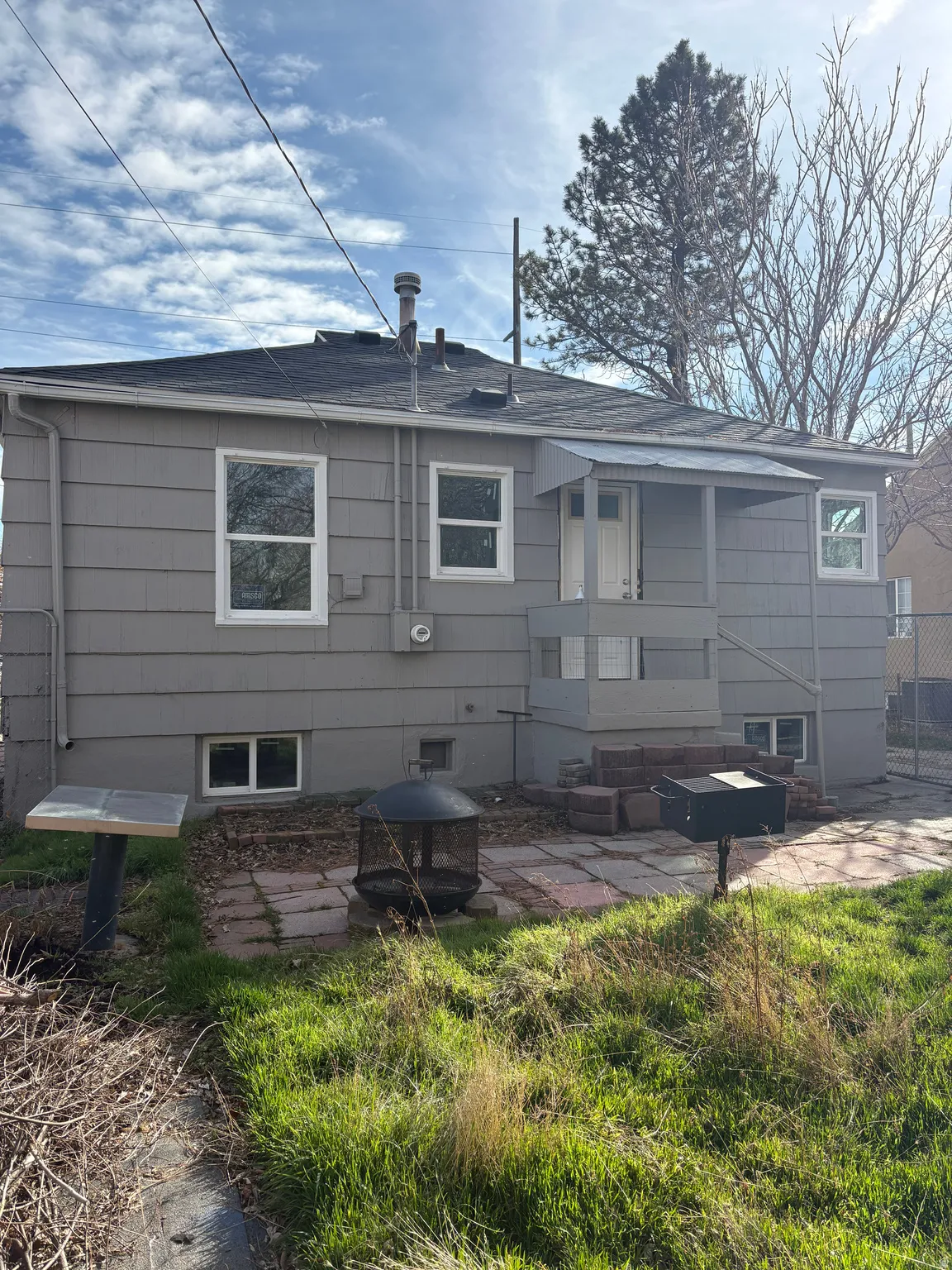 Rear view of property featuring a patio area and roof with shingles