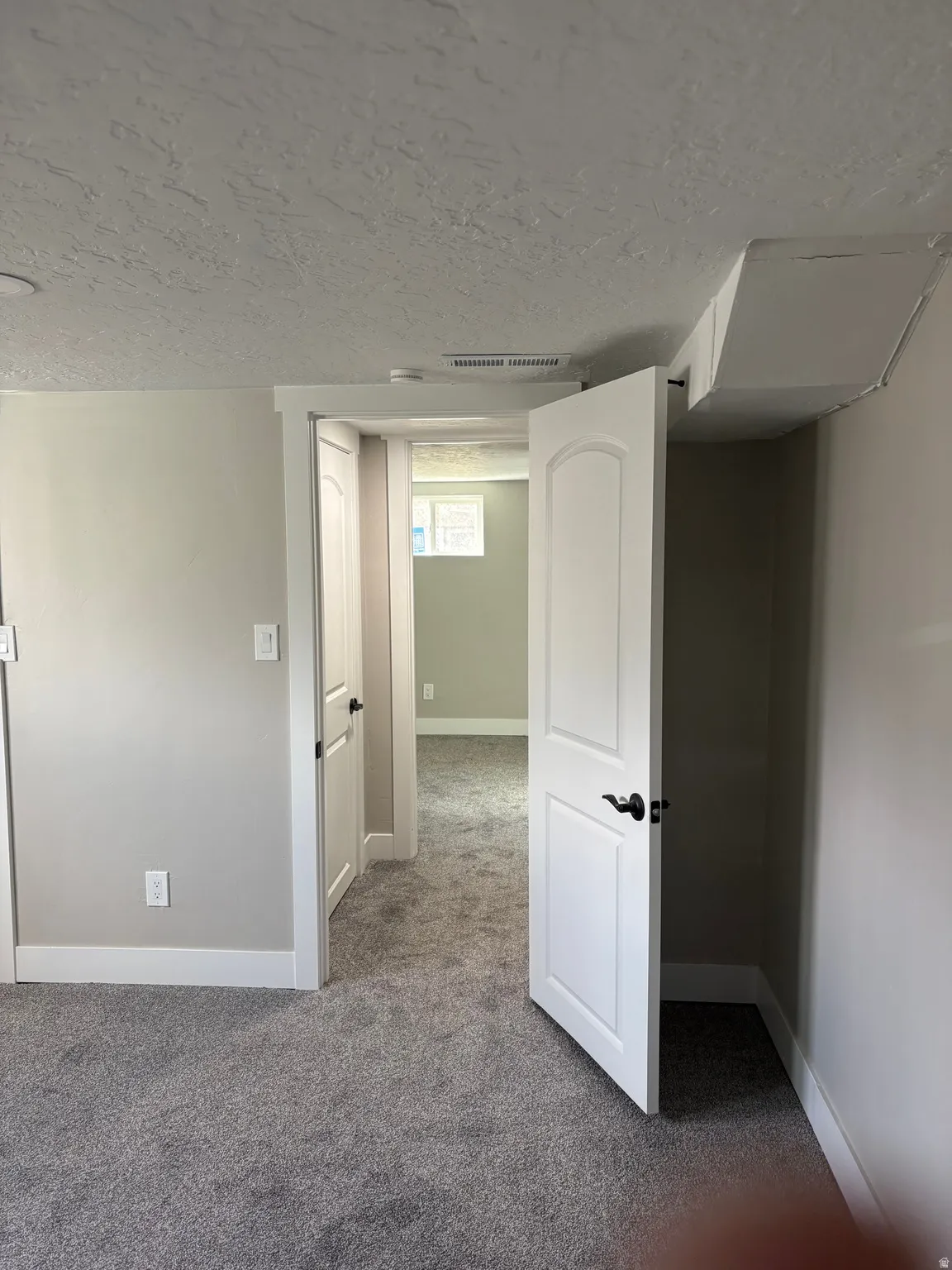 Spare room with dark carpet and a textured ceiling
