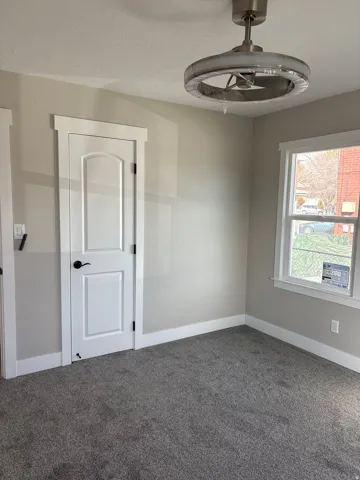 Bedroom 1 closet light colored carpet and a textured ceiling ceiling fan/light