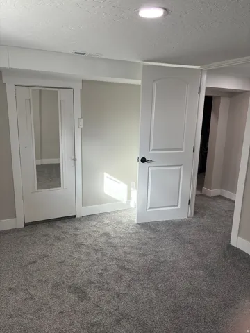 Bedroom 4 closet light grey carpet floors and a textured ceiling