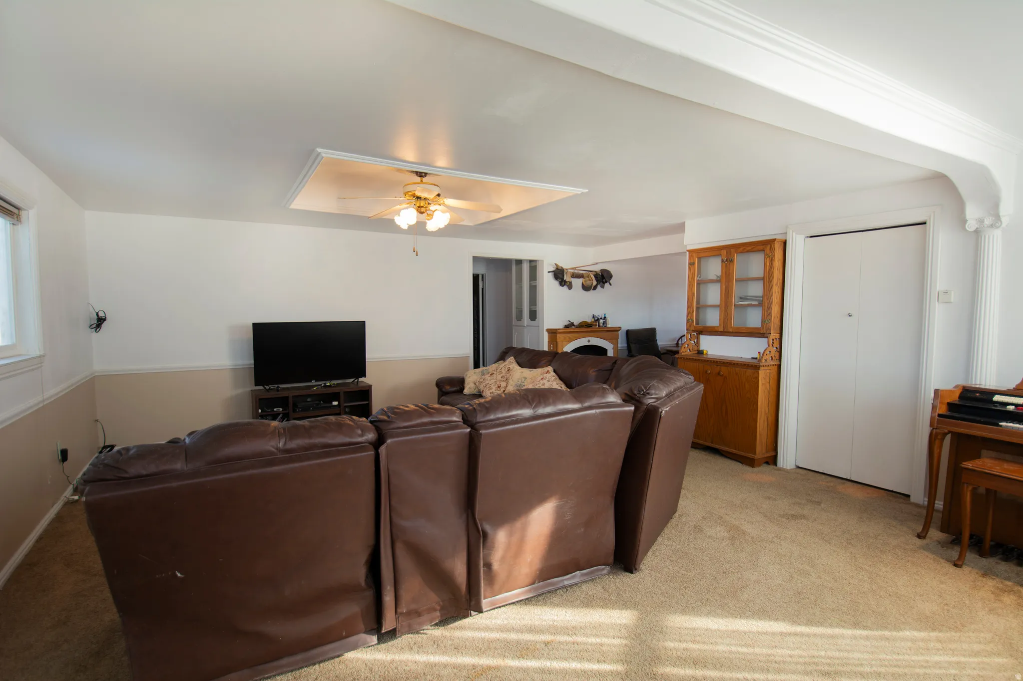 Living room with light carpet and ceiling fan
