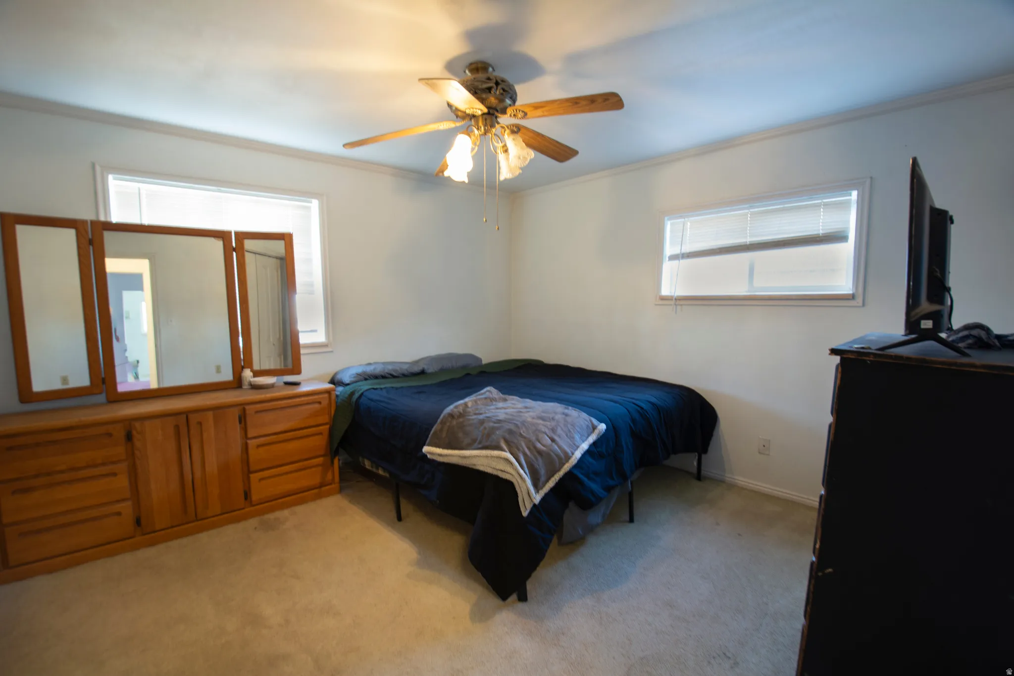 Bedroom featuring light carpet and a ceiling fan