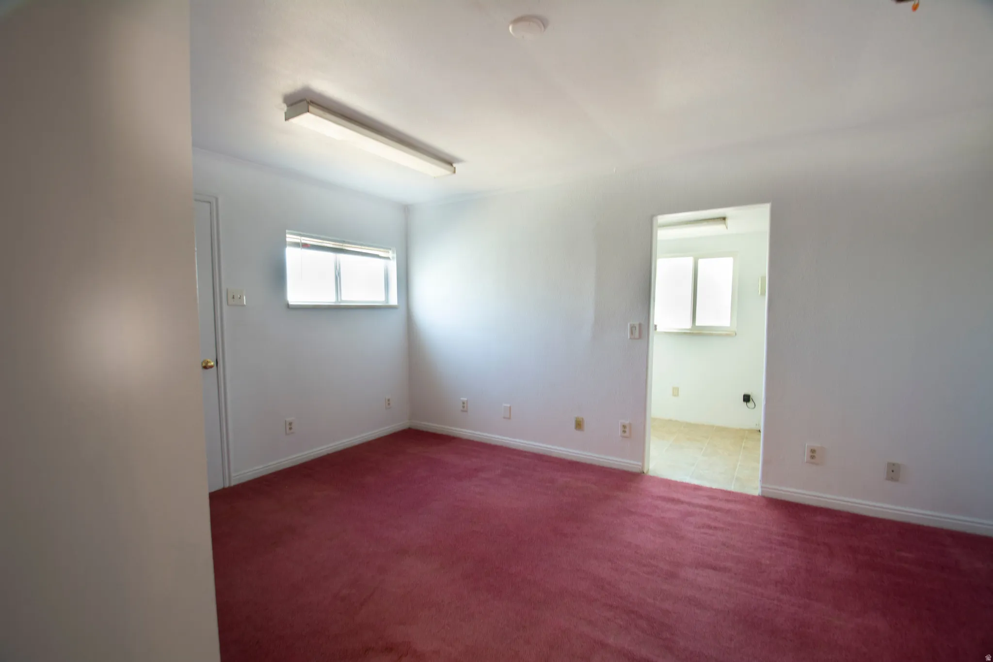 Carpeted spare room featuring baseboards