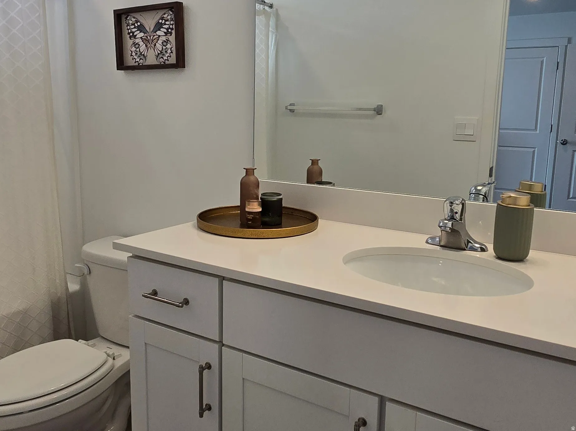Full bath with double vanity, a shower with curtain, and dark wood finished floors