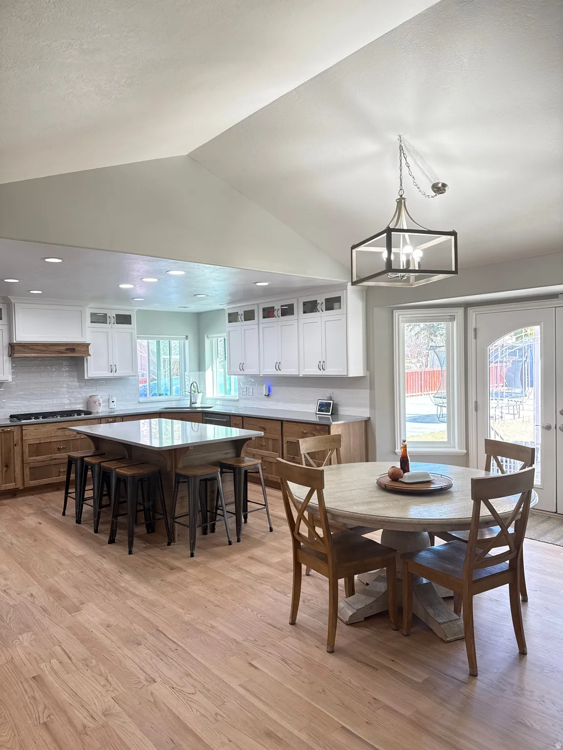 Kitchen/Dining area featuring refinished hardwood floors (2026), upgraded gas range, hickory cabinets, a new island, and recessed lighting.