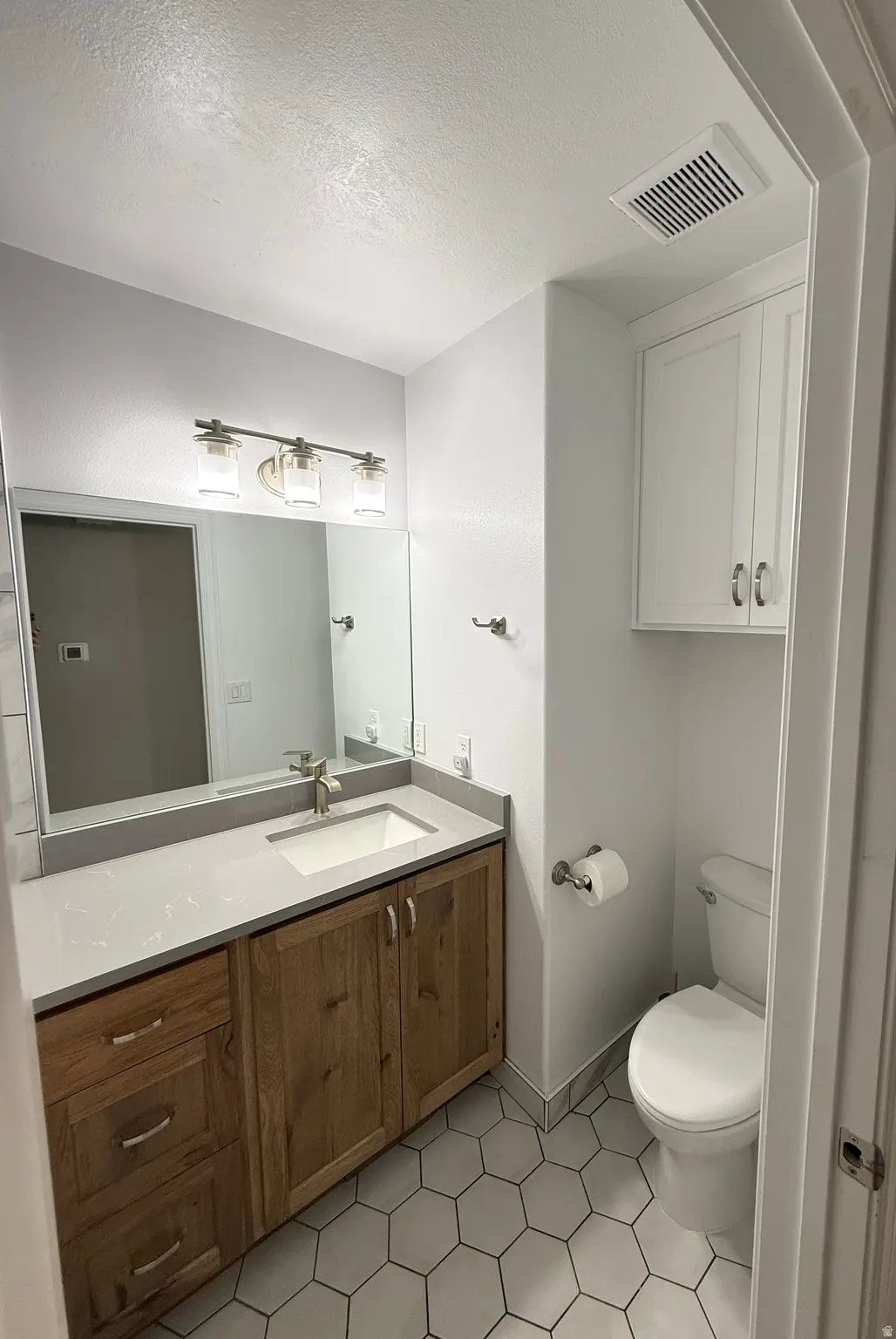 Full bath with upgraded vanity, fixtures, toilet, flooring,and quartz countertop.