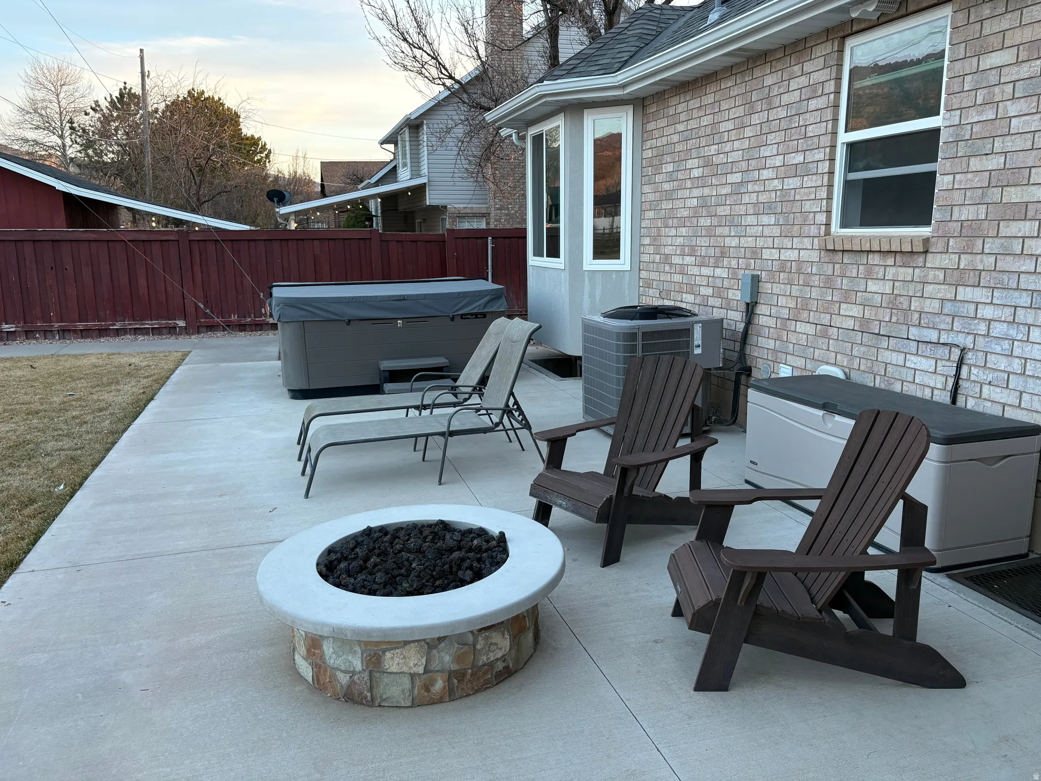 View of uncovered portion of the back patio/terrace with a hot tub and a new gas fire pit.