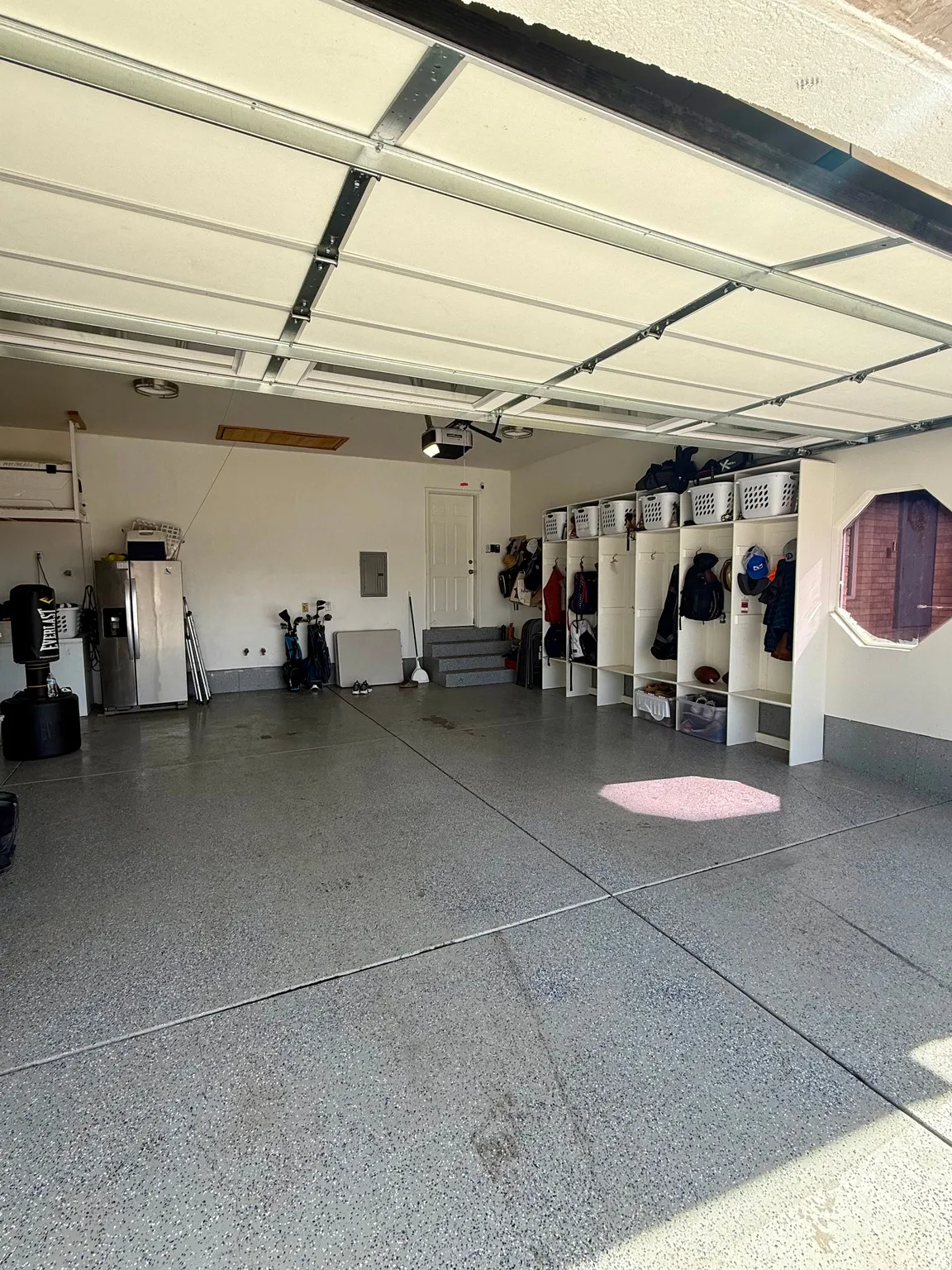 Attached 3-car garage with storage, updated epoxy flooring, and built-in cabinets for organization/storage.