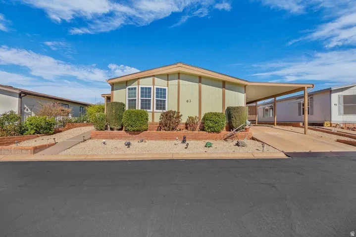 Manufactured / mobile home featuring an attached carport and concrete driveway