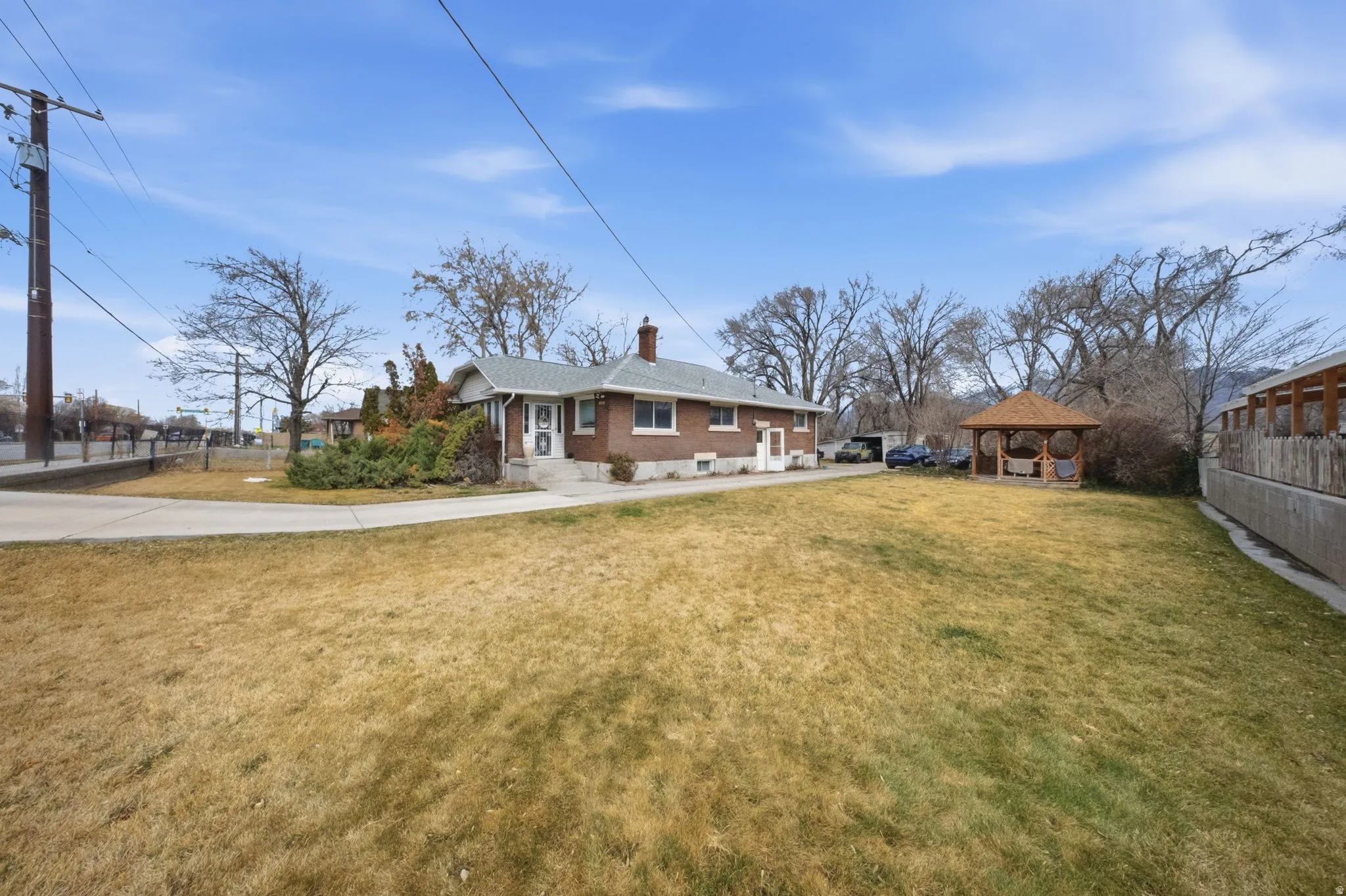 Rear view of property with a gazebo, a chimney, and brick siding