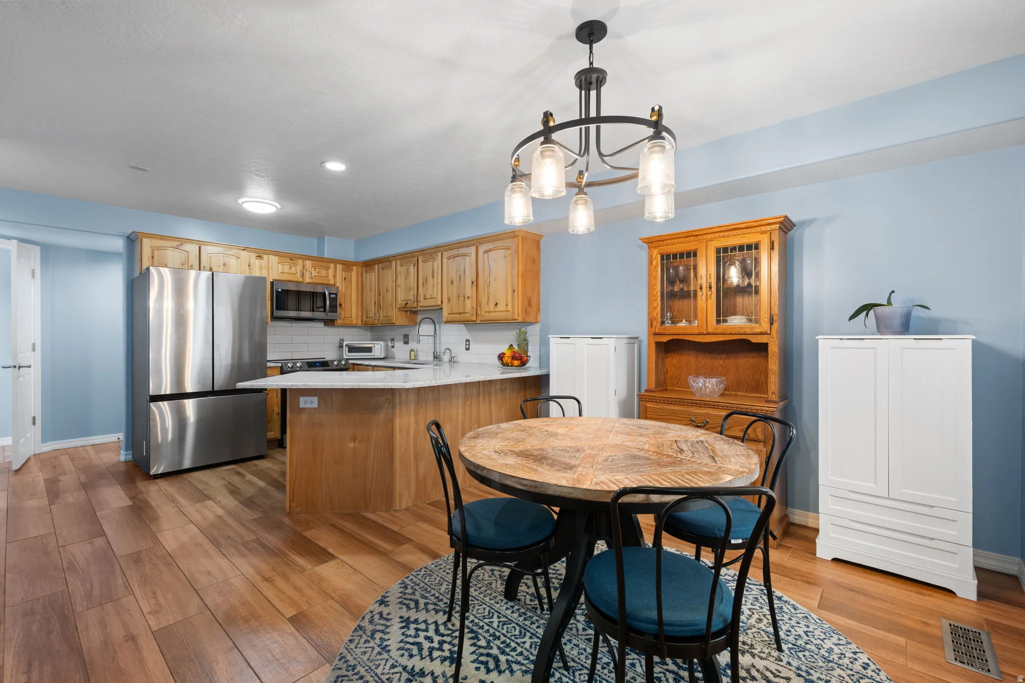 Dining area with ceramic wood tile flooring and upgraded lighting