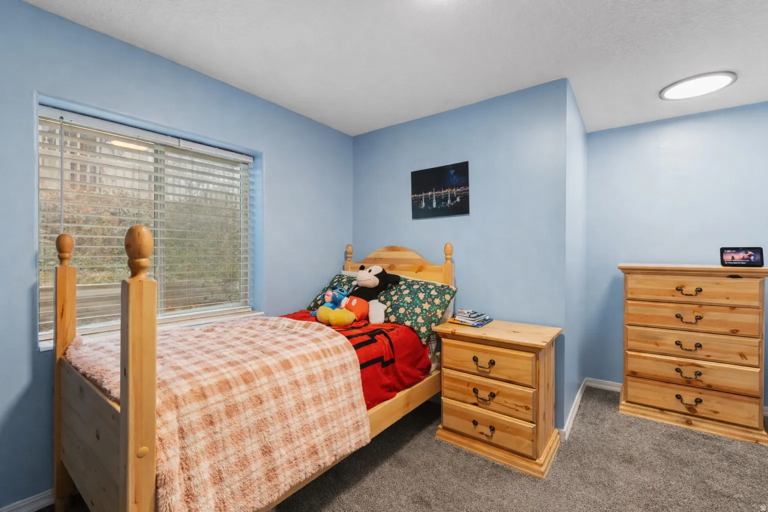 Carpeted bedroom with baseboards and a textured ceiling