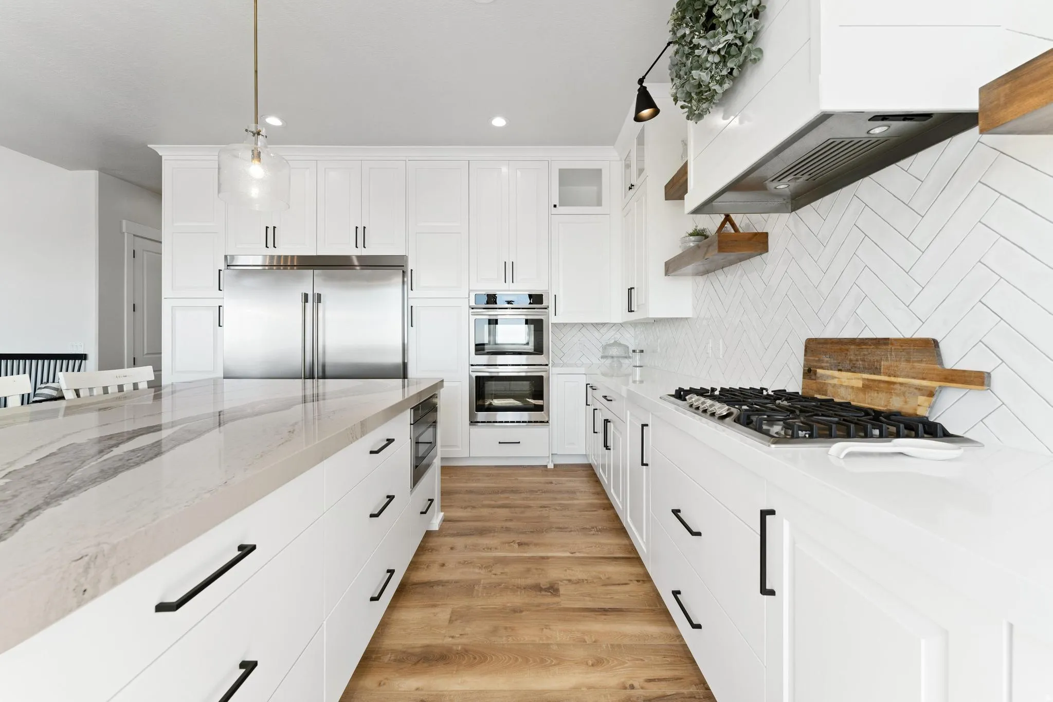 Extra large Kitchen with light stone countertops, built in appliances, white cabinetry, open shelves, and light wood-style floors, 6 foot wide refrig/freezer built-in