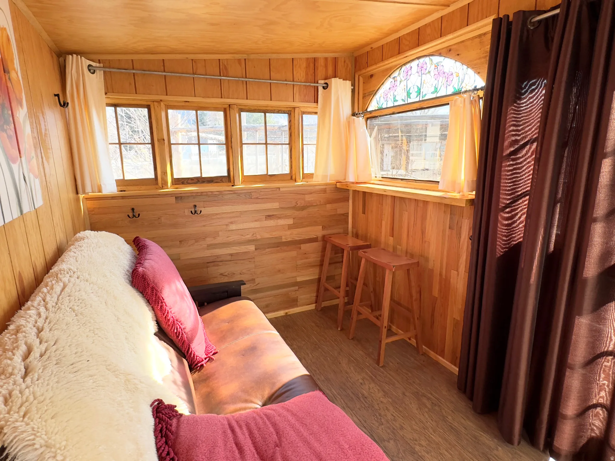 Sitting room with wooden walls, wood finished floors, and a vaulted wood ceiling