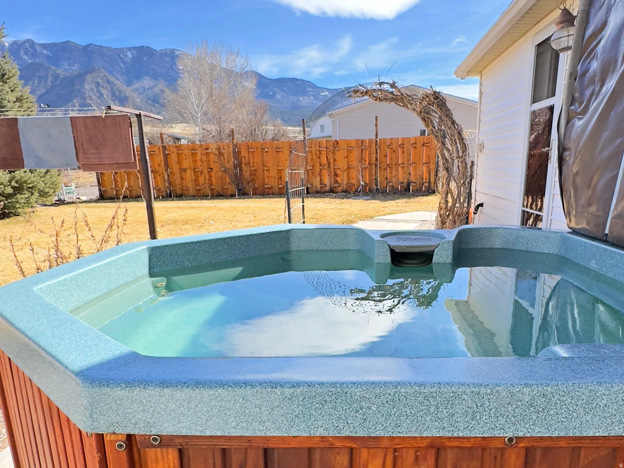 View of patio / terrace featuring a mountain view and a hot tub