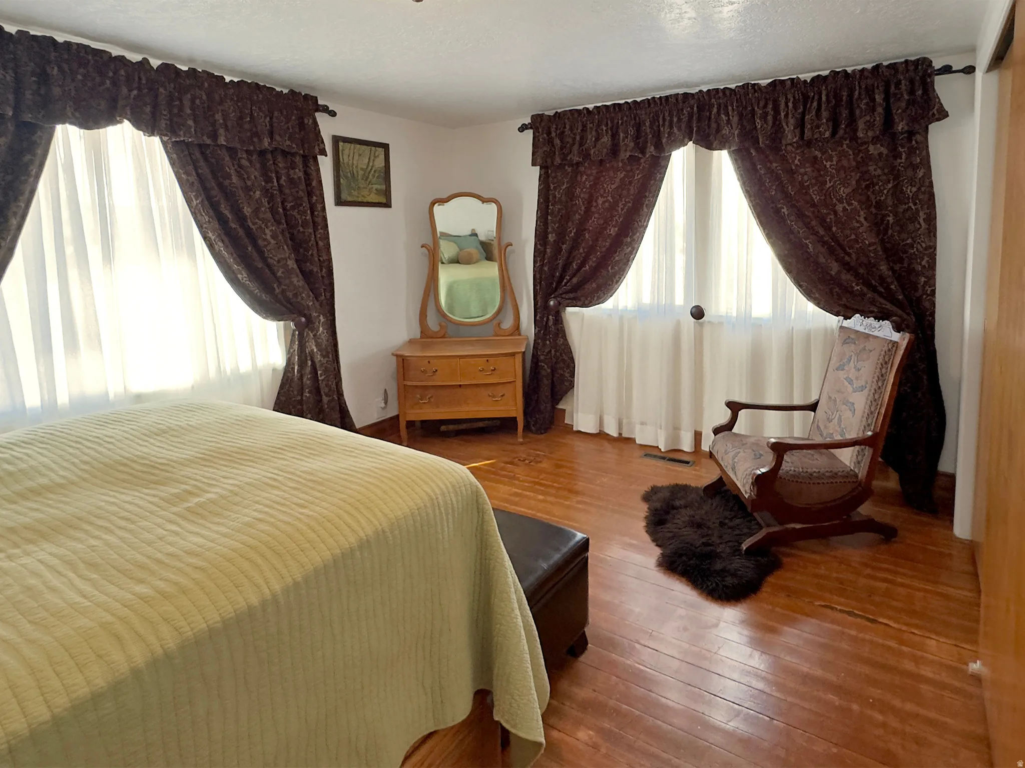 Bedroom featuring multiple windows, wood-type flooring, and a textured ceiling