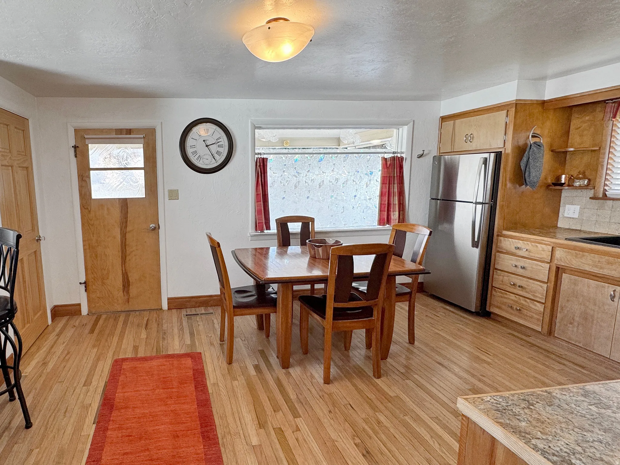 Dining area with a textured ceiling and light wood-style flooring
