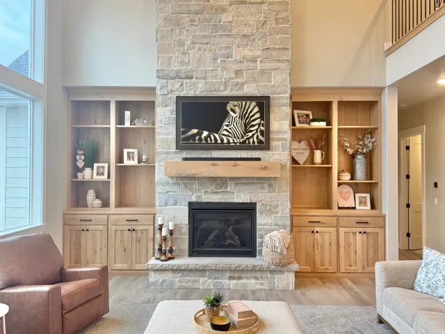 Living area with a high ceiling, a fireplace, and wood finished floors