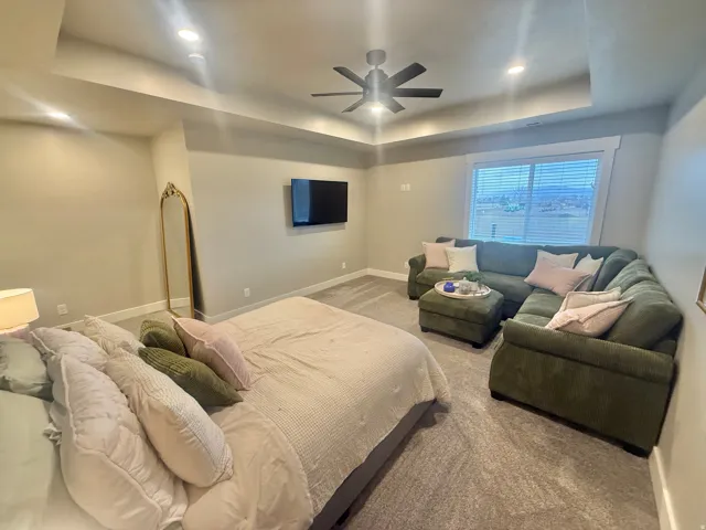 Bedroom featuring a tray ceiling, carpet floors, a ceiling fan, and recessed lighting