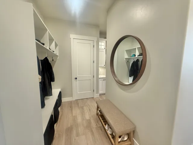 Mudroom featuring light wood-style flooring and baseboards