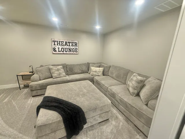 Carpeted living room with recessed lighting and baseboards