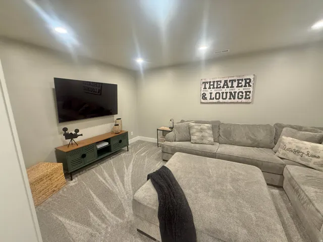 Living area featuring light carpet and recessed lighting