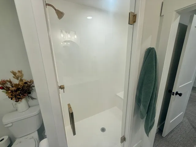 Full bath with a shower stall and toilet