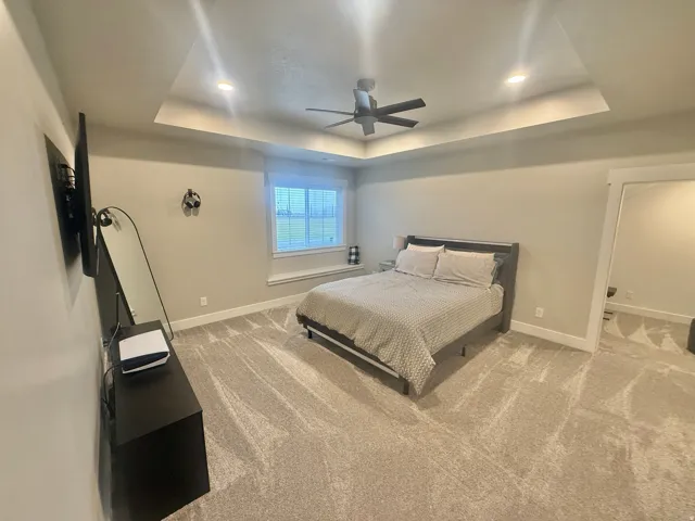 Bedroom featuring light carpet, ceiling fan, and recessed lighting