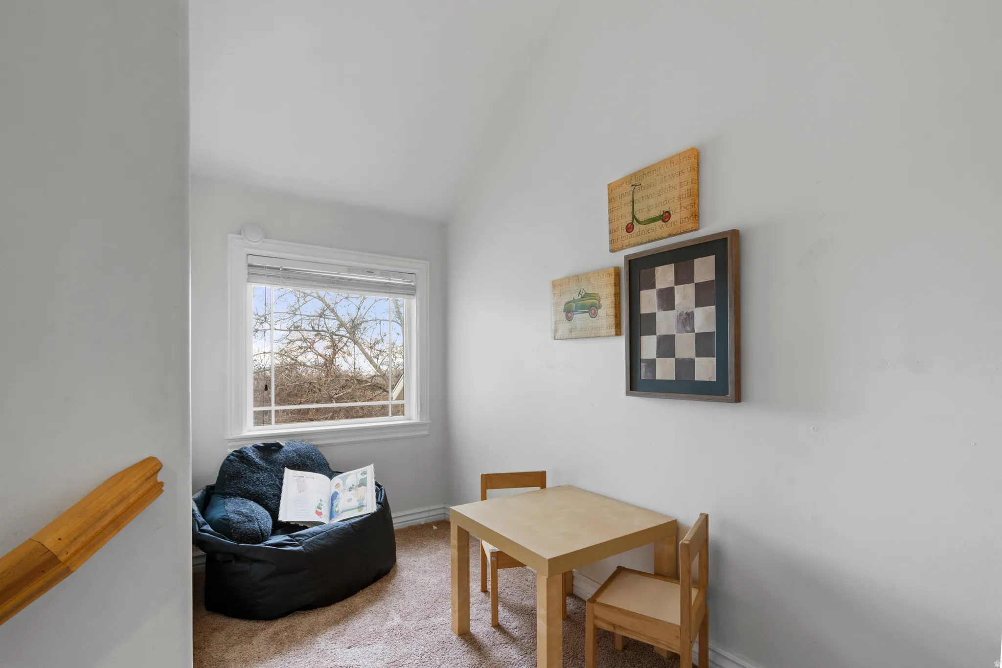 Hallway nook with carpet floors and vaulted ceiling