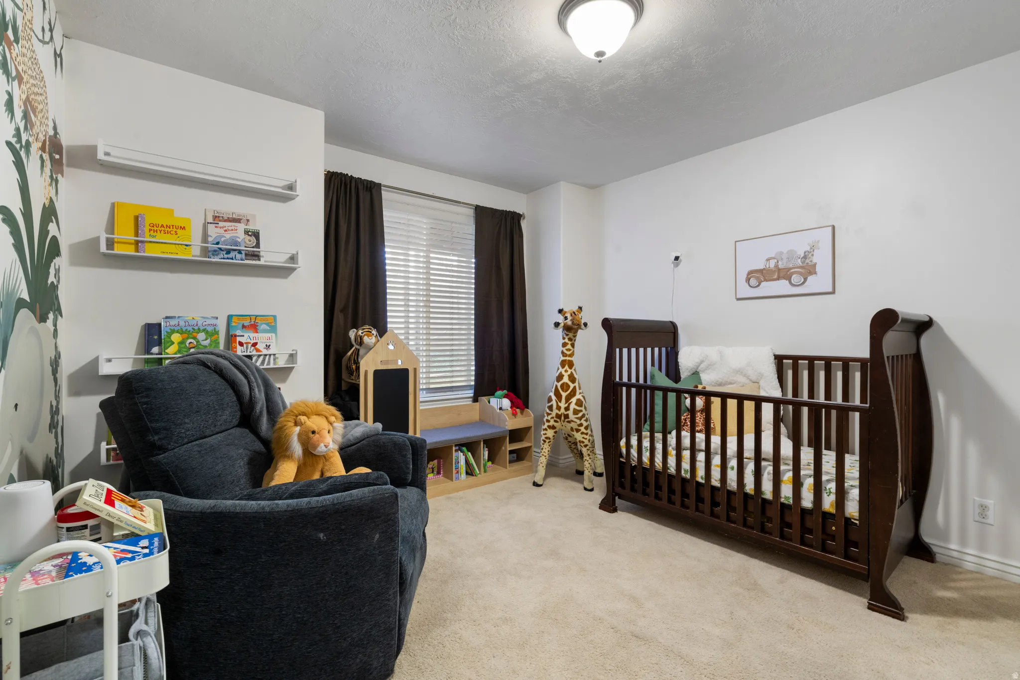 Carpeted bedroom with a crib and a textured ceiling