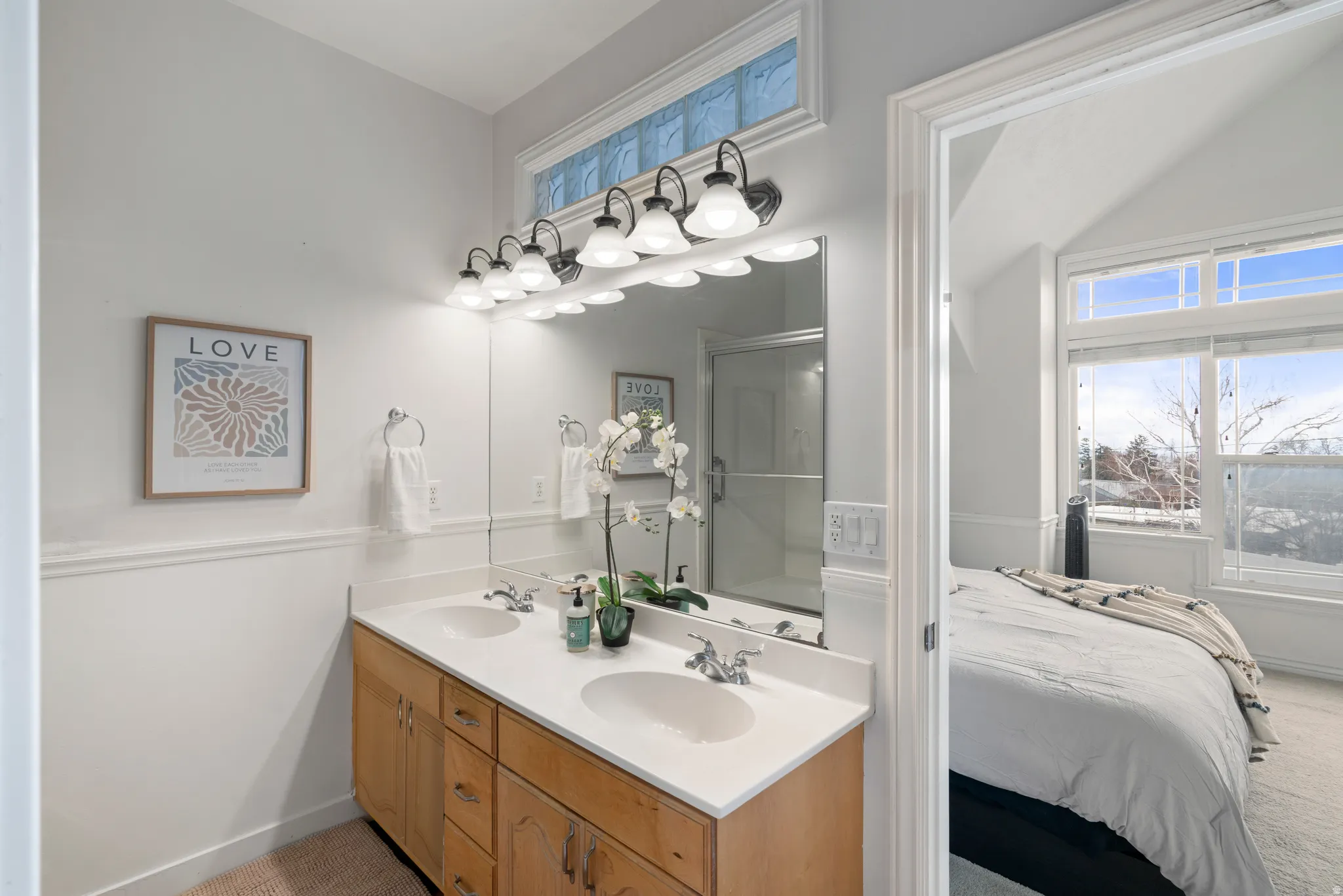 Primary bathroom with double vanity, walk in shower, healthy amount of natural light