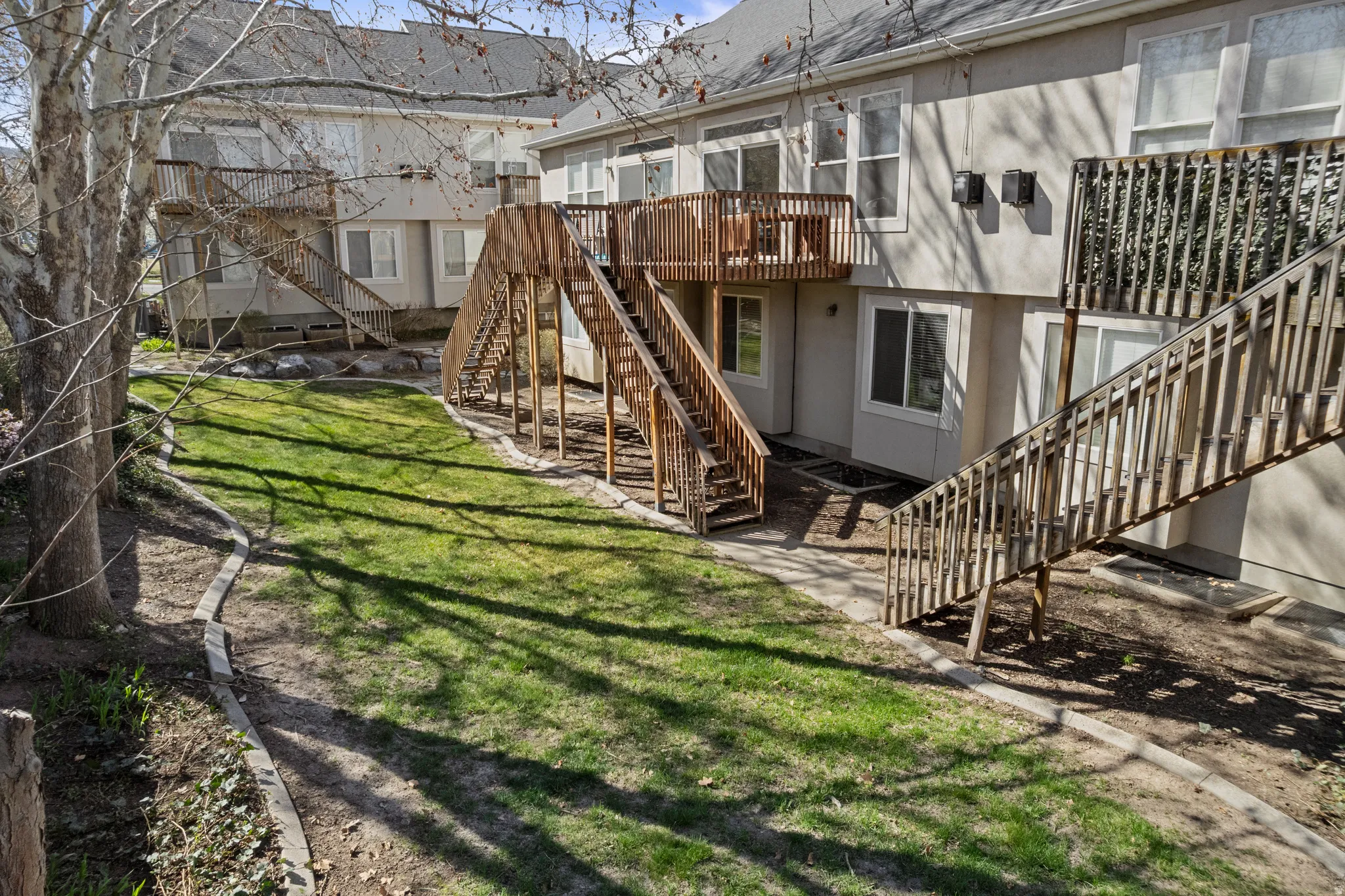 View of green lawn with stairway and a wooden deck