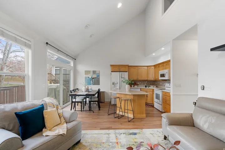 Living area featuring lofted ceiling, light wood-style floors, and recessed lighting