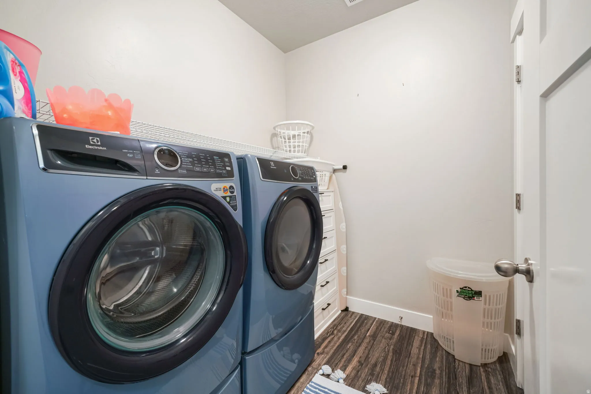 Laundry room with washer and clothes dryer and dark wood-type flooring