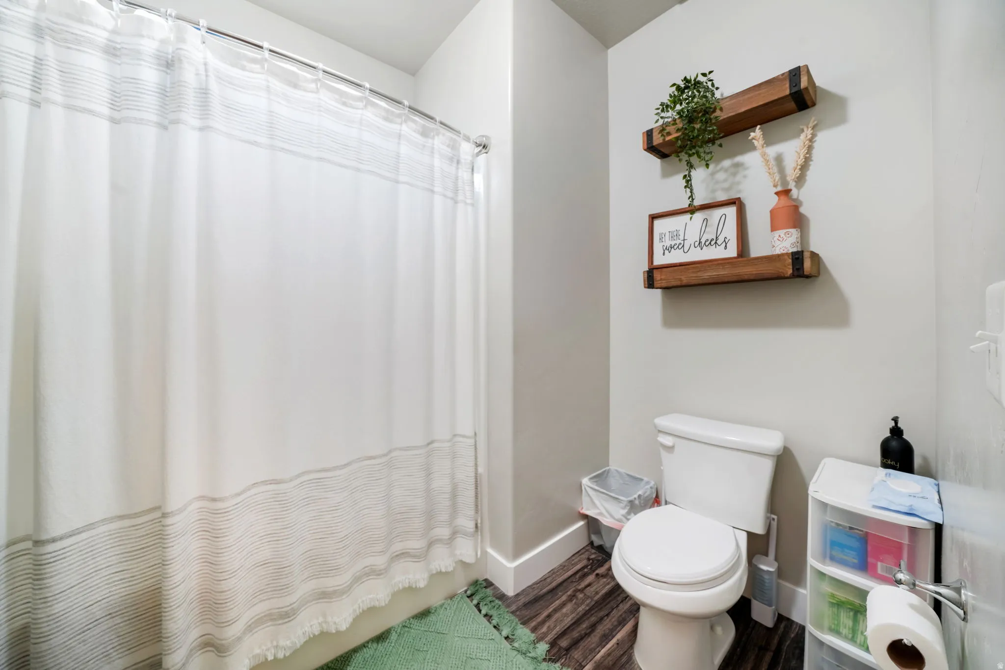 Full bathroom with a shower with shower curtain and dark wood-style flooring