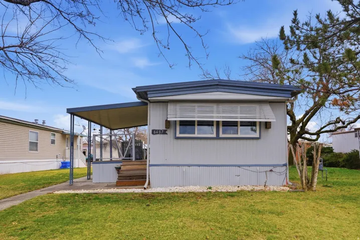 View of front of home with a front lawn and a sunroom