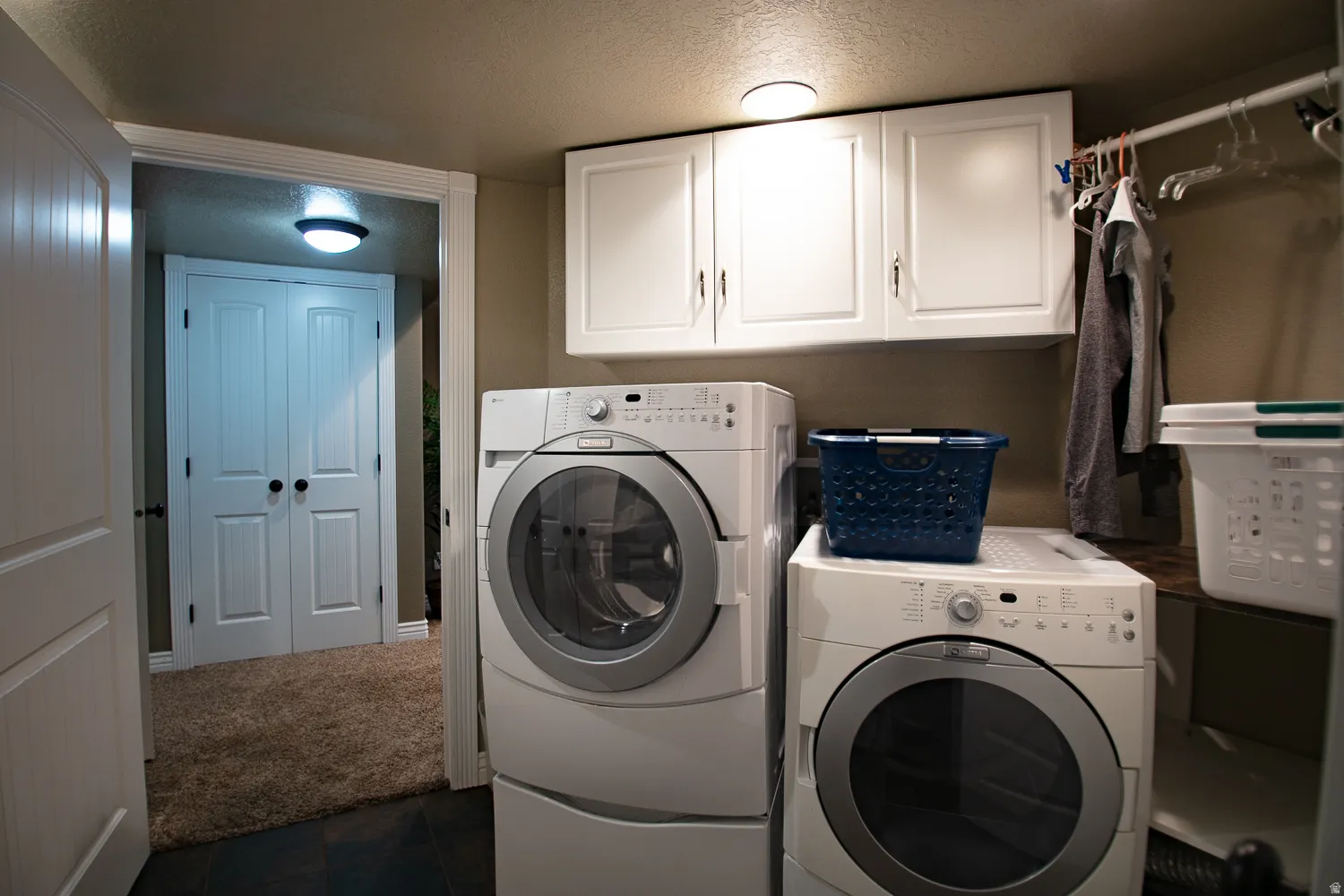 Laundry area with cabinet space, tiled floors, large closets, and mechanical room with two water heaters.