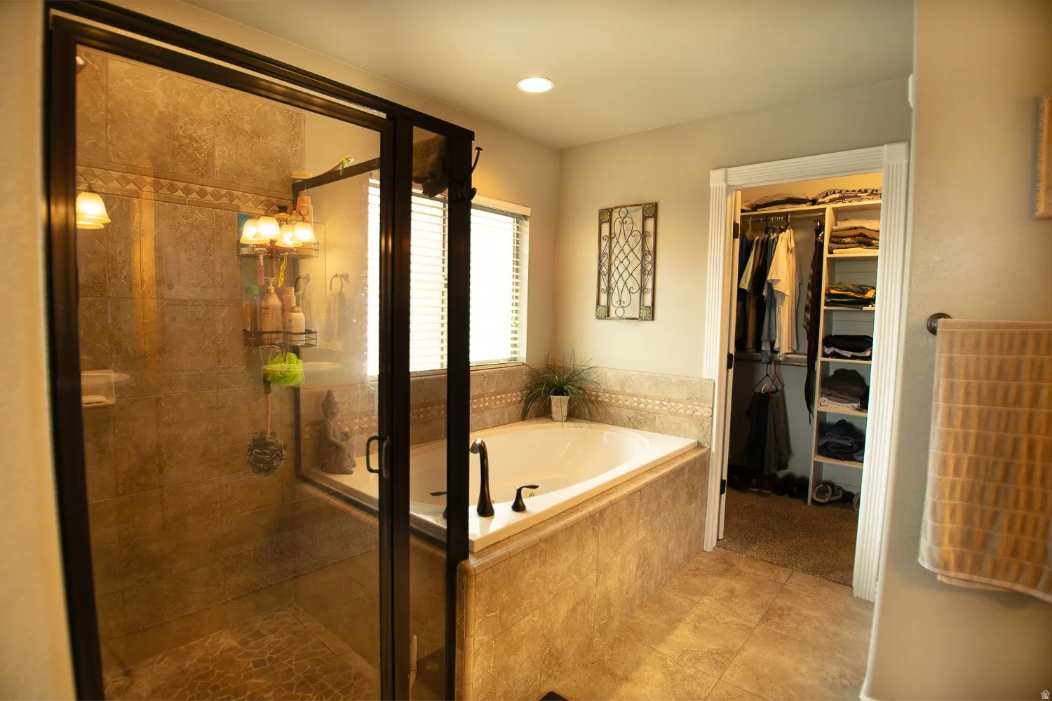 Full bathroom featuring a stall shower, a bath, a spacious closet, light tile patterned floors, and recessed lighting