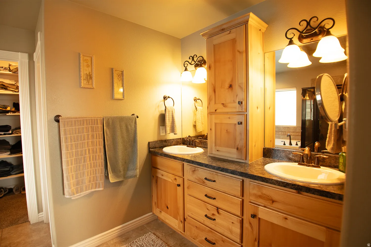 Full bathroom featuring double vanity, a walk in closet, and a garden tub