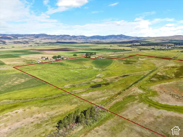 Expansive land parcel featuring open fields, distant mountain backdrop