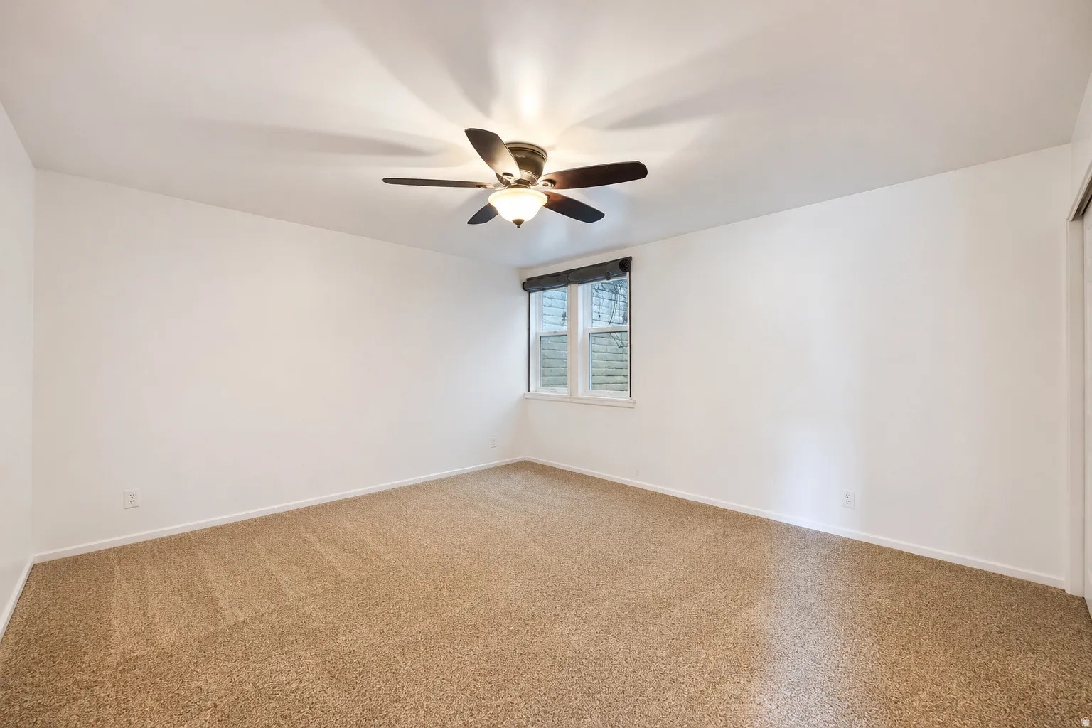 Spacious room featuring neutral carpeting and white walls