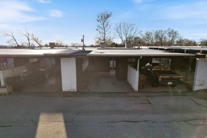 View of parking with an attached carport and driveway