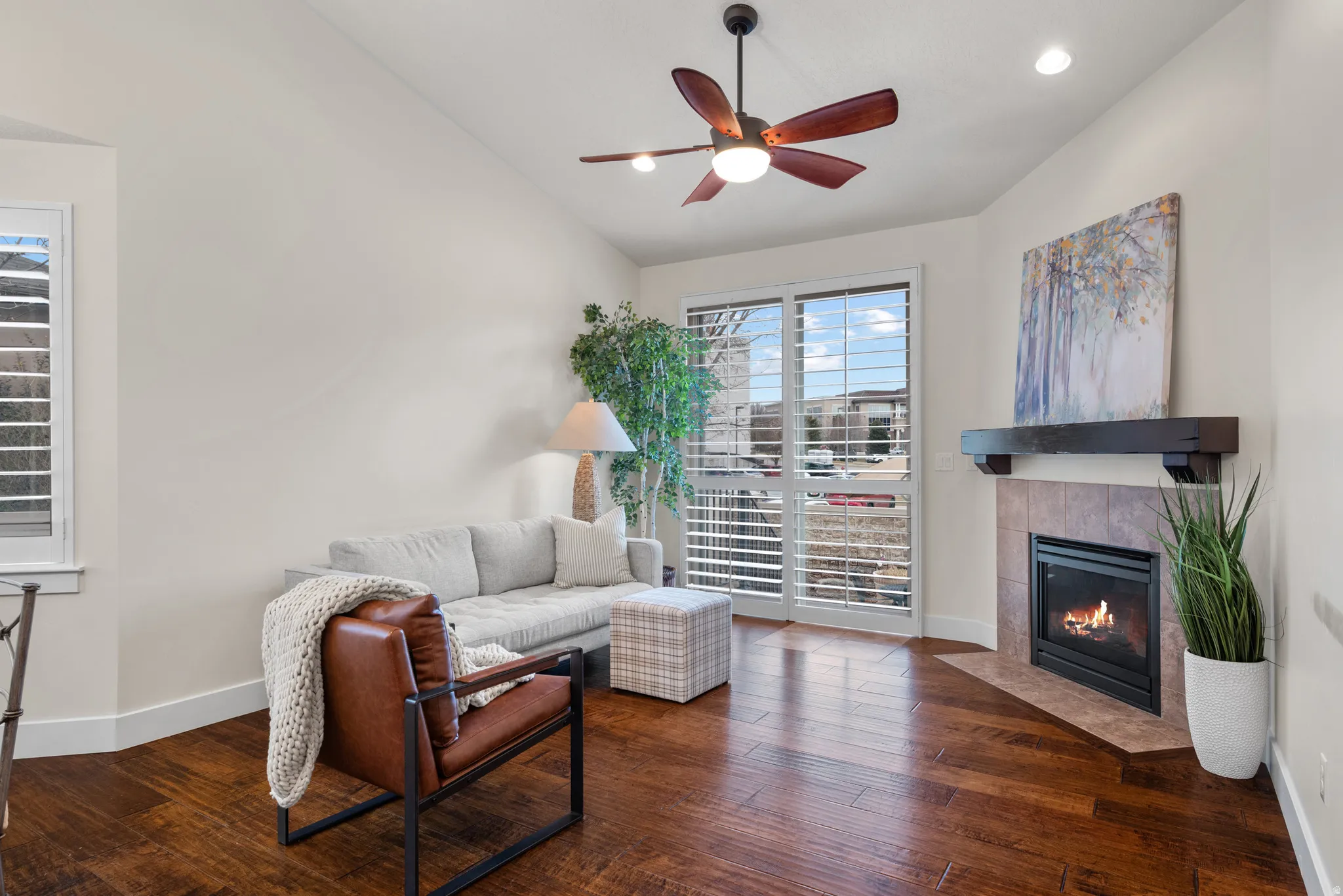 Living room featuring dark wood-style flooring, a ceiling fan, a fireplace, lofted ceiling, and recessed lighting