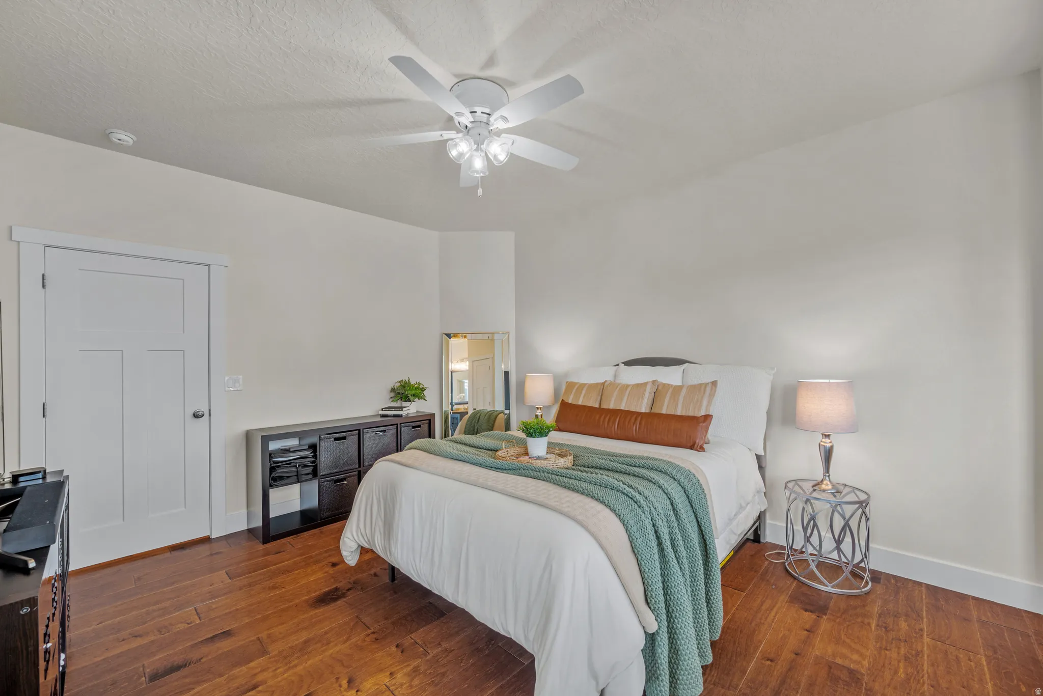 Bedroom featuring dark wood-style flooring, a ceiling fan, and a textured ceiling