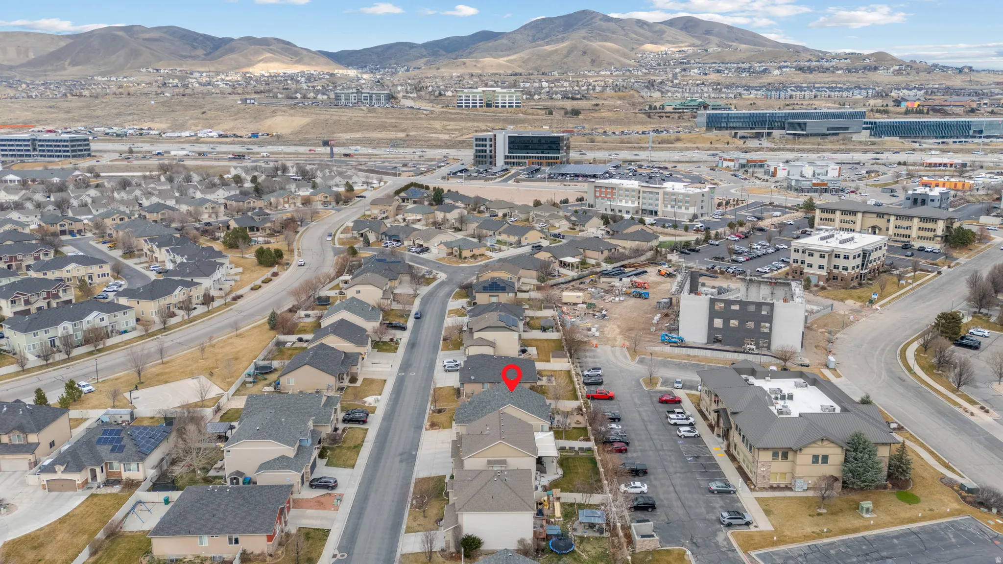 Aerial view of property's location with mountains and nearby suburban area