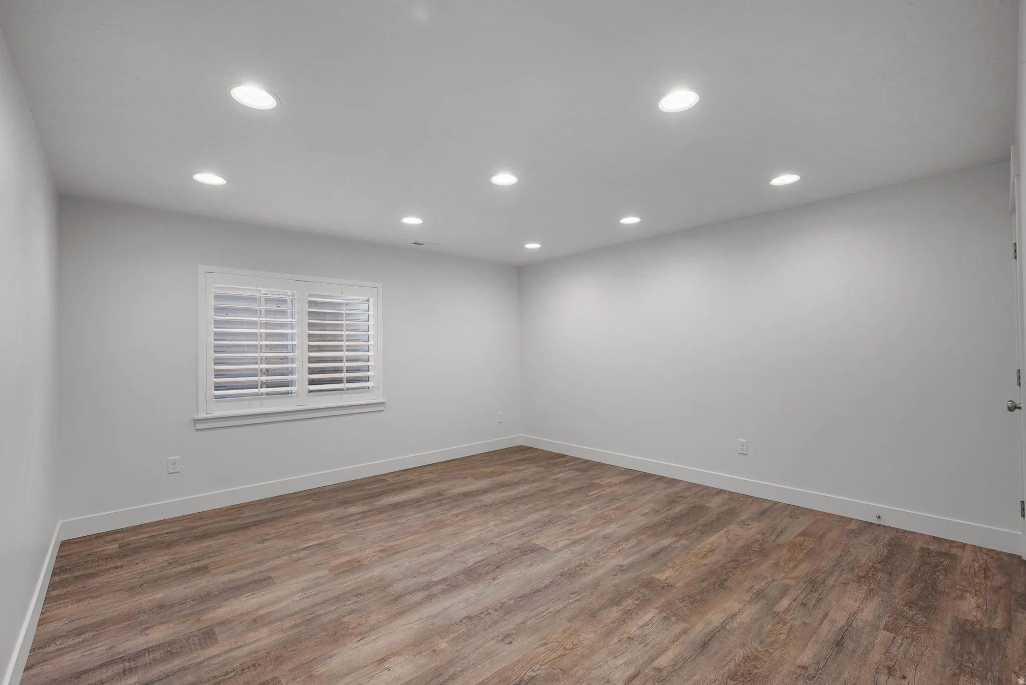 Spare room featuring recessed lighting and dark wood-style flooring
