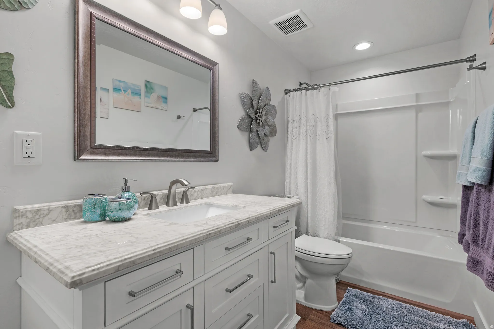 Full bath featuring vanity, shower / tub combo, and dark wood finished floors