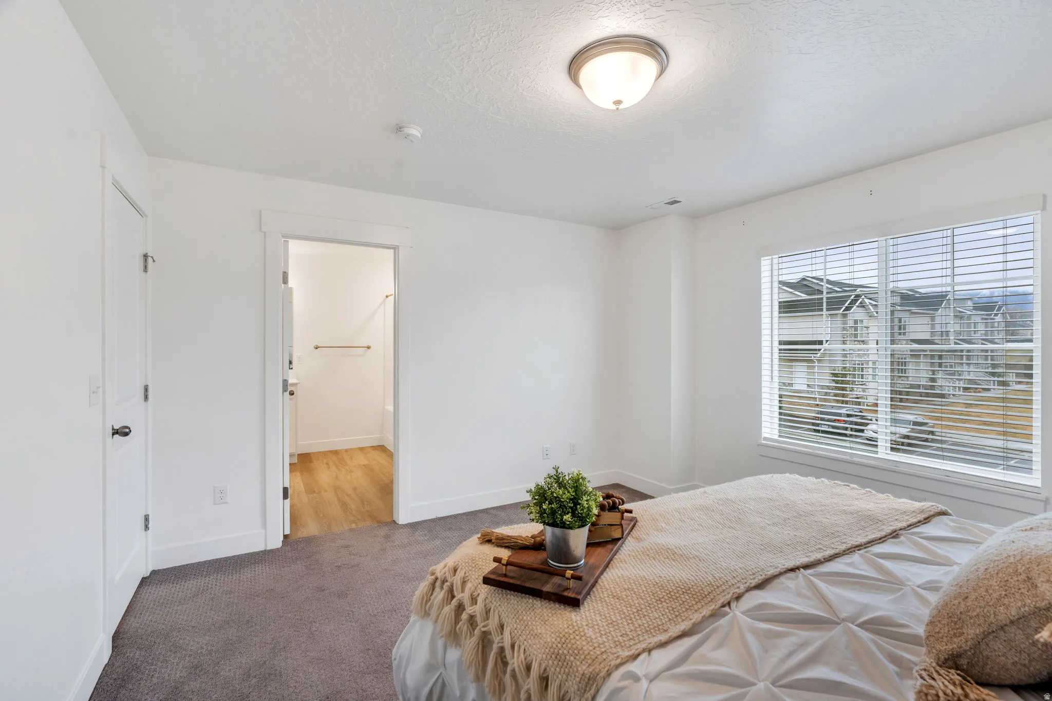 Bedroom featuring a textured ceiling, carpet floors, and ensuite bathroom